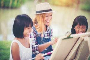 Mother and daughter drawing picture together in the park